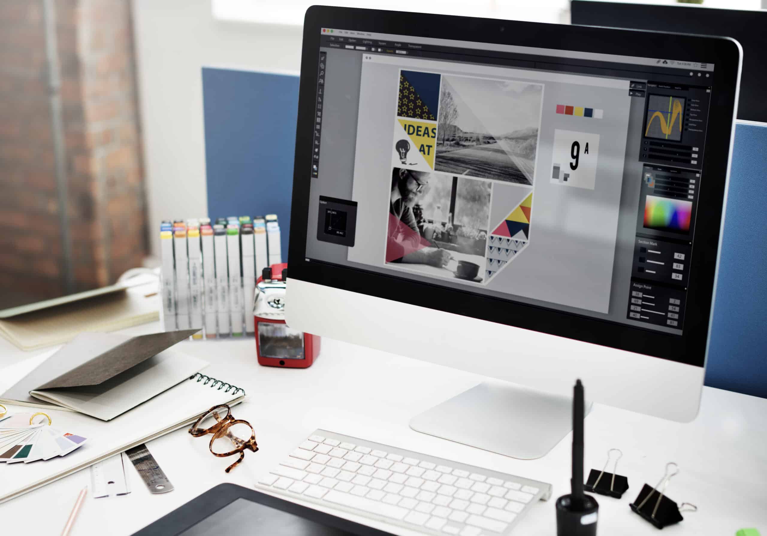 Image d'un ordinateur posé sur un bureau montrant l'interface de la suite Adobe pour la création d'un visuel.